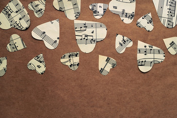 Paper hearts with music notes on craft paper background