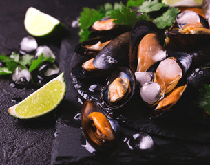 Uncooked mussels on ice with cilantro and coriander