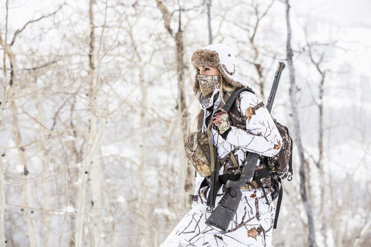 Caucasian woman hunting in forest wearing bandana