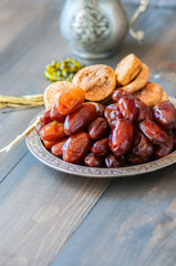Close up of dried date fruits or kurma and figs served on a old vintage plate with ornaments and...
