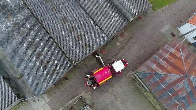 Aerial top down view of modern agricultural machinery manure injector which injects the manure under soil instead of spreading it over grassland machine is loading from manure storage at farm 4k