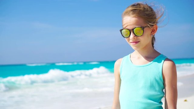 Little girl on the white beach. Portrait of adorable kid on her summer tropical holidays
