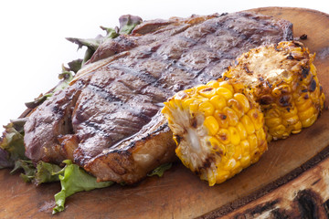 grill steak with corn on a wooden plate