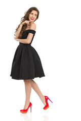 Elegant Woman In Black Cocktail Dress Is Looking Over Shoulder