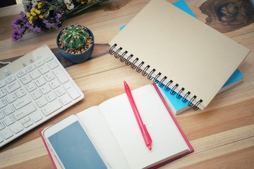 Office desk table with keyboard, notebook, pen and dry bouquet flower. Top view with copy space