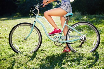 Young women's legs with bicycle