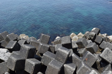 消波ブロック ／ 海岸や河川などの護岸を目的に設置するコンクリートブロックです。海岸沿いに多数のブロックをかみ合わせて並べることで、波のエネルギーを減衰・消散させる事が可能です。また、このブロックにより、水中に複雑で多様な生物生息空間を提供し、円滑な生態系が形成され豊かな水域環境を創り出しています。