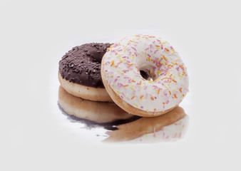 two donuts with chocolate and icing on a white background
