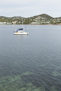 White catamaran on azure water against blue sky, Ibiza