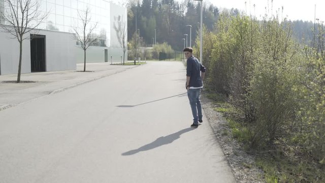 Junger Mann geht tanzend auf der Stra&szlig;e