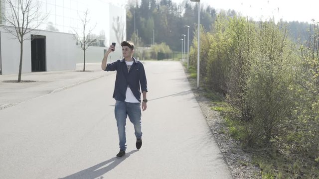 Junger Mann telefoniert mit Smartphone Videotelefonie