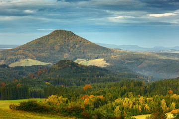 Czech typical autumn landscape. Hills and villages, fall forest. Morning fall valley of Bohemian Switzerland park. Hills with fog, landscape of Czech Republic, Ruzovy vrch, Ceske Svycarsko, Europe.