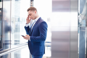 Businessman standing in open Elevator, portrait, front view