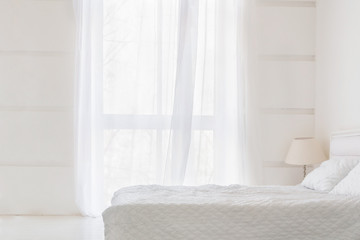 Fototapeta na wymiar White room interior with big window and bed. Abstract white room