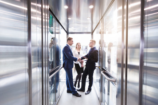 Business team going on elevator and talking