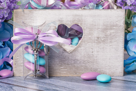 Wedding Favors. Boxes With Purple And White Ribbon Containing Violet And Blue Confetti And Key Gift.