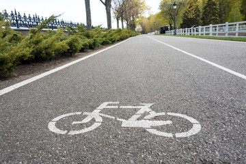 Obraz premium Bicycle sign on the road. Bike lane in the park