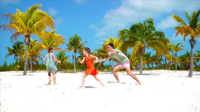 Happy family at tropical beach having fun. Father and little kids enjoy time together on white sandy beach on vacation