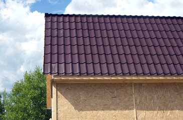 Naklejka premium Suburban house construction with OSB panels on sunny summer day