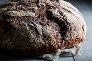 Homemade and fresh bread with several grains on dark table