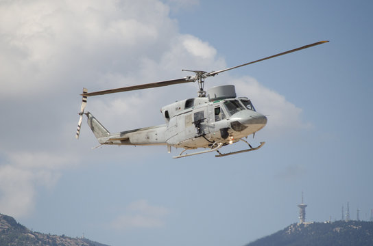 Helicopter bell uh 1 approach landing. right machine gun view. mountain background with aviation antenna