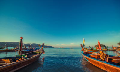 Fototapeta na wymiar Longtale boat at the Thai beach. Paradice sand beach place. Boats on the clear water and blue sunrise sky.