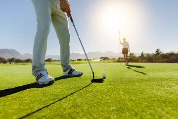 Papier Peint photo Lavable Golf Golfeur mettant la balle avec la partenaire féminine tenant le drapeau sur le golf cou