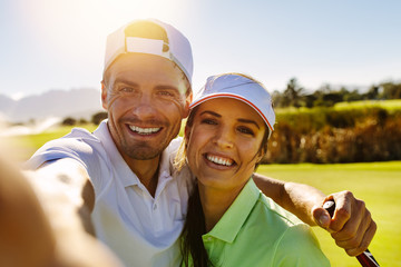 Heureux jeune couple prenant selfie au terrain de golf