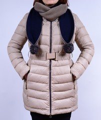 Winter down jacket isolated on a grey background. Fashionable beige coat with scarf on model...
