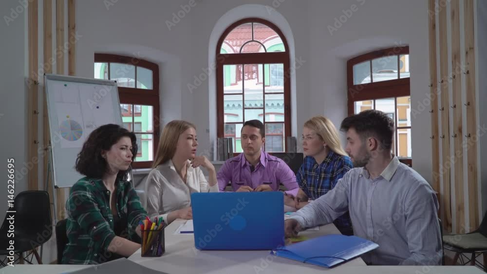 Aufkleber Young employees sitting in the boardroom discussing new project. Manager conducts a presentation explain and pointing some item on screen laptop.