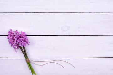 Fototapeta premium Fresh pink flowers hyacinths on white wooden table. Top view, copy space.