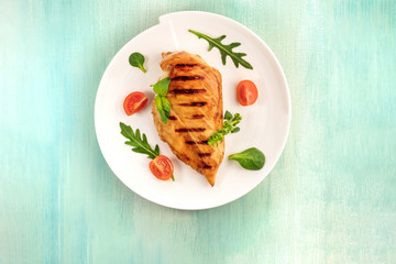 Grilled chicken fillet with cherry tomatoes and salad leaves