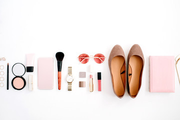 Beauty blog fashion concept. Female pink styled accessories: cell phone, watches, sunglasses, notebook, cosmetics, shoes on white background. Flat lay, top view trendy feminine background.