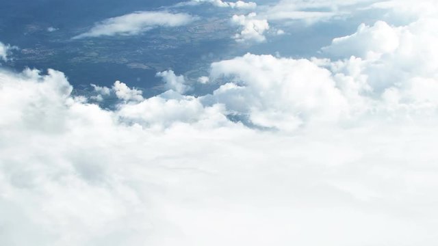 3D CGI animation of flying through white clouds towards ground visible from distance 