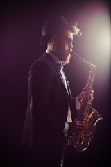 Obraz na płótnie Canvas Bearded man performing on a saxophone