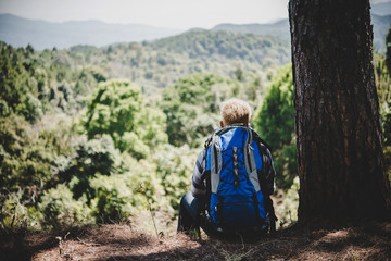 Fototapeta na wymiar Young man hiking sitting relax and admire nature.