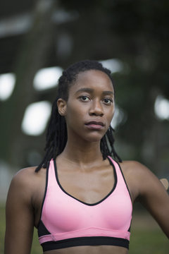 Serious Mixed Race woman wearing pink sports-bra