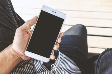 closeup hand holding smartphone with soft-focus in the background, over light