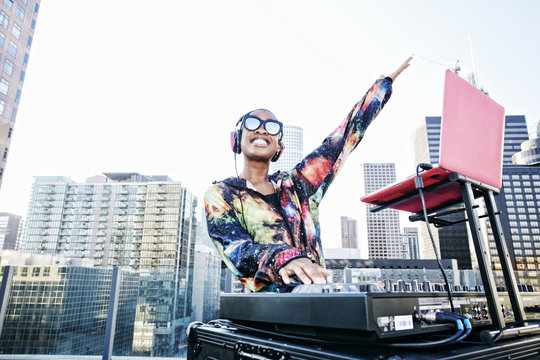Female DJ with headphones enjoying music on rooftop party