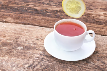cup of tea with lemon on wooden background