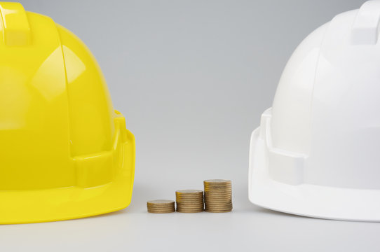 Step pile gold coins between yellow and white engineer hat
