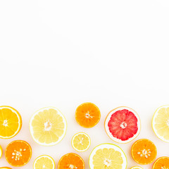 Tasty fruit background. Sliced citrus fruits on white background. Flat lay, top view.