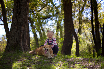little girl with corgi dog outdoors