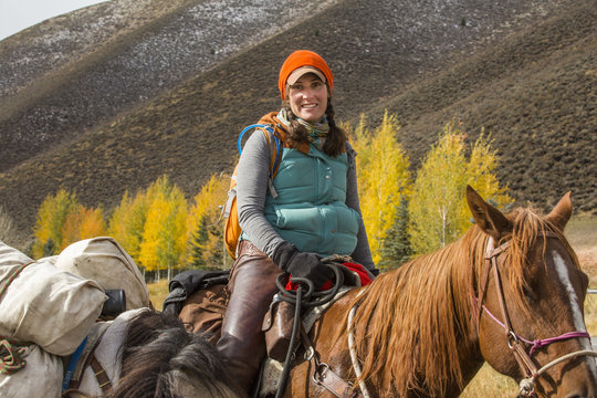 Smiling Caucasian woman riding horse in winter