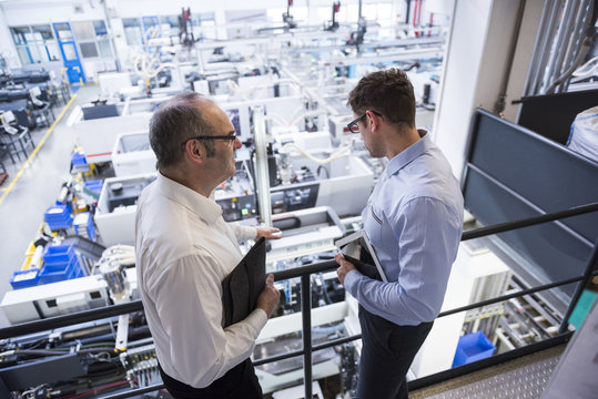 Two men talking in factory shop floor