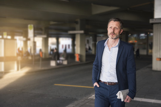 Portrait of mature businessman waiting at bus terminal