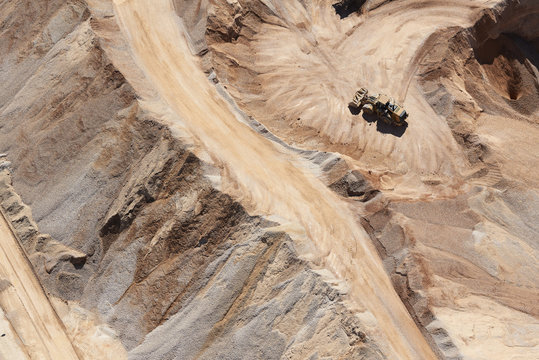 USA, Texas, aerial view of sand mine near San Antonio with a grader moving sand