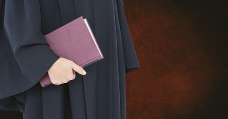 Midsection of judge holding book