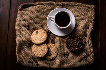 Coffee with cookies and coffee beans on coffee sack