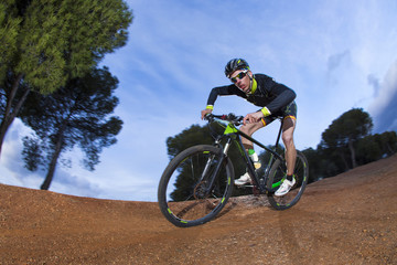 Cyclist man riding mountain bike on mountain.